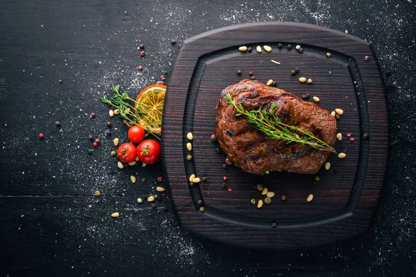 Gemide baharat ile dana biftek. Üstten Görünüm. Metin için özgür yer. Ahşap bir arka plan üzerinde.