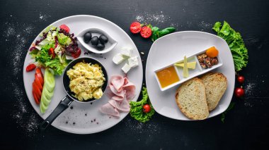 İngiliz kahvaltısı. Yumurta, zeytin, taze sebze, fındık, Kuru Meyve ve bal. Üstten Görünüm. Metin için özgür yer. Ahşap bir arka plan üzerinde.