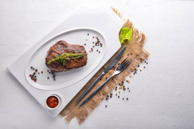 Dana biftek bir plaka üzerinde. Üstten Görünüm. Metin için özgür yer. Ahşap bir arka plan üzerinde.