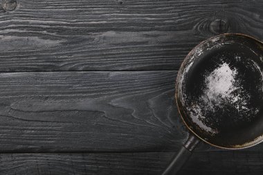 Kızartma tavası. Ahşap siyah bir arka plan üzerinde. Üstten Görünüm. Metniniz için boş alan.