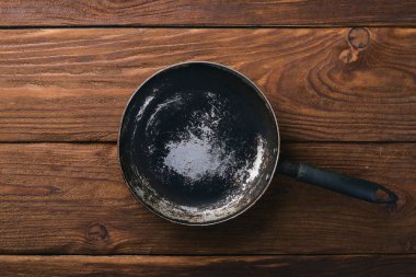 Kızartma tavası. Ahşap siyah bir arka plan üzerinde. Üstten Görünüm. Metniniz için boş alan.