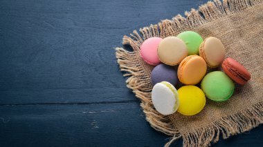 Renkli macarons kek. Ahşap bir arka plan üzerinde. Üstten Görünüm. Metniniz için boş alan.