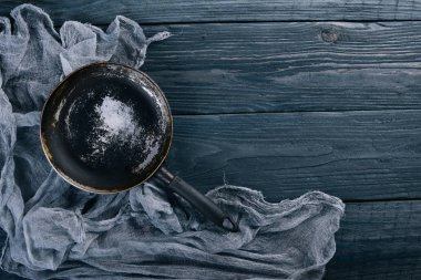 Kızartma tavası. Ahşap siyah bir arka plan üzerinde. Üstten Görünüm. Metniniz için boş alan.