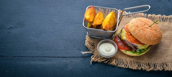 Burgare och potatis med sås. På en trä bakgrund. Ovanifrån. Fritt utrymme för din text. — Stockfoto