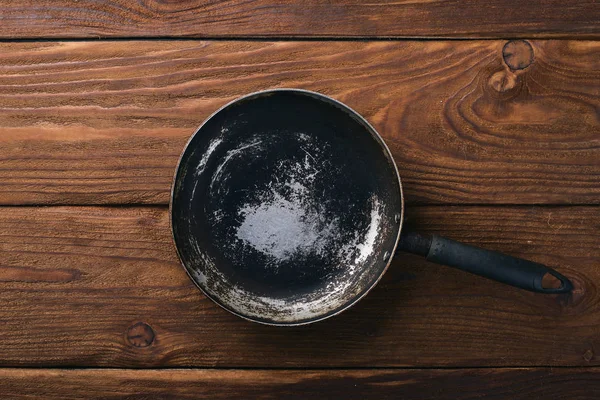 Stekpanna. På en trä svart bakgrund. Ovanifrån. Fritt utrymme för din text. — Stockfoto