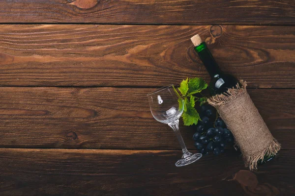 Una botella de vino y uvas. Sobre un fondo de madera. Vista superior. Espacio libre para tu texto . —  Fotos de Stock