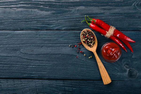 Sıcak baharat biber ve baharat kırmızı biber. Ahşap bir arka plan üzerinde. Üstten Görünüm. Metniniz için boş alan.