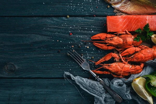 Frutos do mar. Vómer de peixe, lagosta, salmão. Em um fundo de madeira. Vista superior. Espaço livre para texto . — Fotografia de Stock