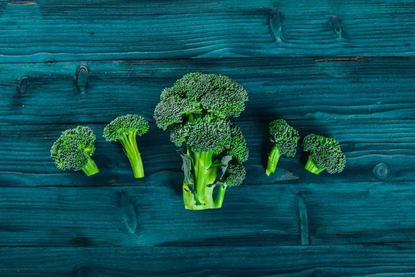 Broccoli op een houten oppervlak. Bovenaanzicht. Vrije ruimte voor tekst. — Stockfoto