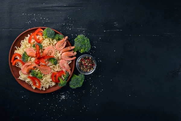Ázsiai ételeket, a tenger gyümölcsei és a zöldségek. Garnéla, brokkoli, paprika, fűszerek. Felülnézet. Szabad hely a szöveg. — Stock Fotó