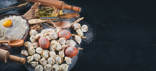 Традиционные русские пельмени, равиоли, пельмени с мясом на черном бетонном фоне. Вид сверху. Copyspace
.