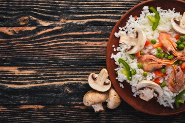 Risotto ile karides ve sebze. Deniz ürünleri. Asya mutfağı. Ahşap doku arka plan. Üstten Görünüm. Boş alan.