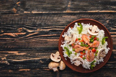 Risotto ile karides ve sebze. Deniz ürünleri. Asya mutfağı. Ahşap doku arka plan. Üstten Görünüm. Boş alan.