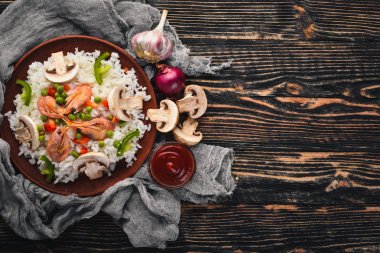 Risotto ile karides ve sebze. Deniz ürünleri. Asya mutfağı. Ahşap doku arka plan. Üstten Görünüm. Boş alan.