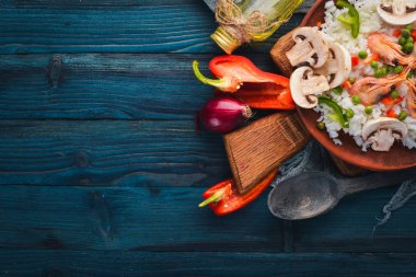 Risotto ile karides ve sebze. Deniz ürünleri. Asya mutfağı. Ahşap doku arka plan. Üstten Görünüm. Boş alan.