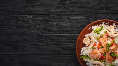 Risotto ile karides ve sebze. Deniz ürünleri. Asya mutfağı. Ahşap doku arka plan. Üstten Görünüm. Boş alan.