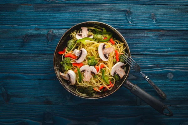 Noodles with vegetables in a frying pan. Asian Cuisine Pasta. Top view. Free space. On a wooden background.; — Stock Photo, Image