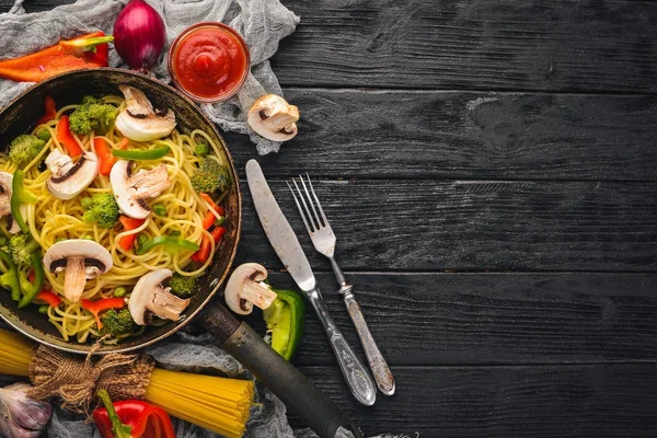 フライパンで野菜と麺。アジア料理のパスタ。平面図です。空きスペース。木製の背景に.; — ストック写真