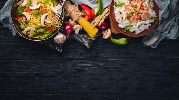 Conjunto de cocina asiática. Risotto con fideos de camarones con verduras. Mariscos. Sobre un fondo de textura de madera. Vista superior. Espacio libre . — Foto de Stock