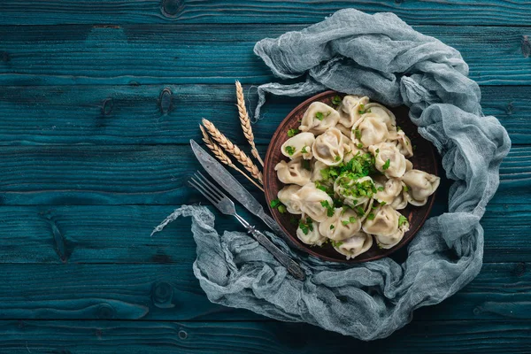 Lezzetli ev yapımı etli hamur köfteleri ya da ahşap masaya taze maydanoz serpiştirilmiş Rus pelmeni, kopya alanı, yukarıdan görüş. — Stok fotoğraf