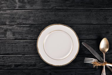 Plaka ve eski çatal bıçak takımı. Ahşap bir arka plan üzerinde. Üstten Görünüm. Metin için boş alan.