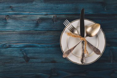 Plaka ve eski çatal bıçak takımı. Ahşap bir arka plan üzerinde. Üstten Görünüm. Metin için boş alan.