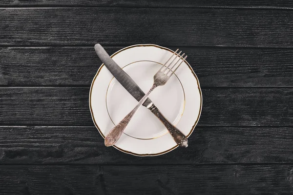 Plate and old cutlery. On a wooden background. Top view. Free space for text. — Stock Photo, Image