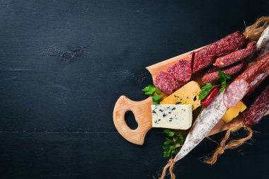 Peynir ve ahşap arka plan üzerinde geleneksel sosis ürün yelpazesine. Brie peyniri, mavi peynir, gorgonzola, fuete, salam. Metin için özgür yer. Üstten Görünüm.