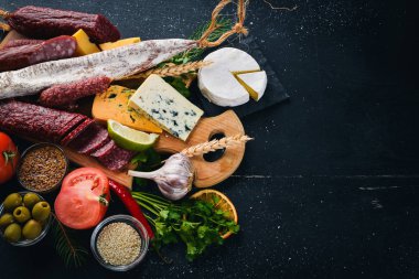Peynir ve ahşap arka plan üzerinde geleneksel sosis ürün yelpazesine. Brie peyniri, mavi peynir, gorgonzola, fuete, salam. Metin için özgür yer. Üstten Görünüm.