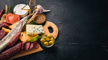 Peynir ve ahşap arka plan üzerinde geleneksel sosis ürün yelpazesine. Brie peyniri, mavi peynir, gorgonzola, fuete, salam. Metin için özgür yer. Üstten Görünüm.