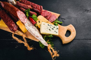 Peynir ve ahşap arka plan üzerinde geleneksel sosis ürün yelpazesine. Brie peyniri, mavi peynir, gorgonzola, fuete, salam. Metin için özgür yer. Üstten Görünüm.