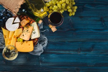 Peynir, şarap, bal, fındık ve Baharatlar, mavi ahşap bir masa üzerinde bir geniş ürün yelpazesine sahip. Üstten Görünüm. Metin için boş alan.