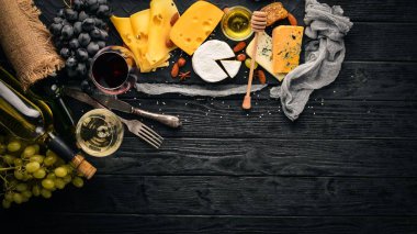 Ürün yelpazesine peynirler, brie peyniri, gorgonzola, mavi peynir, üzüm, bal, fındık, kırmızı ve beyaz şarap, ahşap bir masa üzerinde bir büyük. Üstten Görünüm. Metin için boş alan.