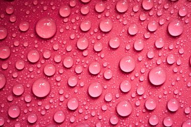 Kırmızı arkaplanda su damlaları.