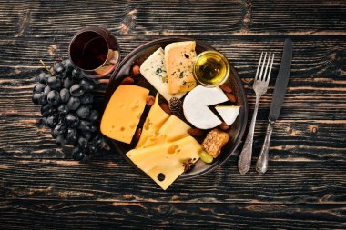 Ürün yelpazesine peynirler, brie peyniri, gorgonzola, mavi peynir, üzüm, bal, fındık, kırmızı ve beyaz şarap, ahşap bir masa üzerinde bir büyük. Üstten Görünüm. Metin için boş alan.