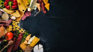 Çeşitli peynir, sosis, şaraplar, geleneksel baharat ve ahşap arka plan üzerinde taze sebze. Peynir brie, mavi peynir, gorgonzola, fuete, salam. İtalyan ve İspanyol mutfağı. Boş alan.