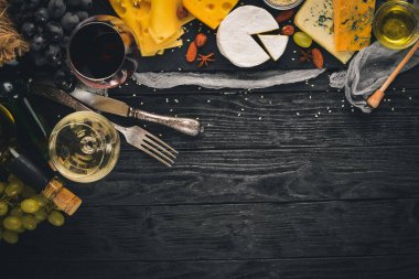 Ürün yelpazesine peynirler, brie peyniri, gorgonzola, mavi peynir, üzüm, bal, fındık, kırmızı ve beyaz şarap, ahşap bir masa üzerinde bir büyük. Üstten Görünüm. Metin için boş alan.