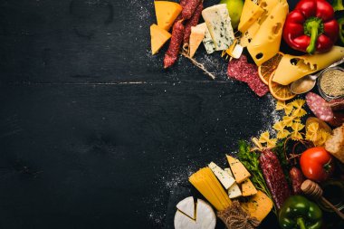 Çeşitli peynir, sosis, şaraplar, geleneksel baharat ve ahşap arka plan üzerinde taze sebze. Peynir brie, mavi peynir, gorgonzola, fuete, salam. İtalyan ve İspanyol mutfağı. Boş alan.