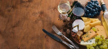 Bir şişe şarap ve peynir, bal, fındık ve Baharatlar, ahşap bir masa üzerinde büyük bir ürün yelpazesine. Üstten Görünüm. Metin için boş alan.