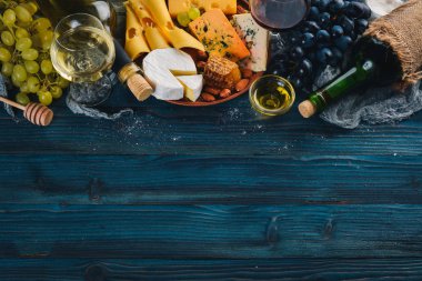 Peynir, şarap, bal, fındık ve Baharatlar, mavi ahşap bir masa üzerinde bir geniş ürün yelpazesine sahip. Üstten Görünüm. Metin için boş alan.