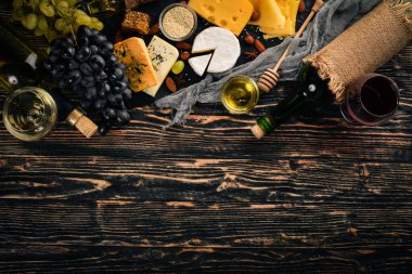 Ürün yelpazesine peynirler, brie peyniri, gorgonzola, mavi peynir, üzüm, bal, fındık, kırmızı ve beyaz şarap, ahşap bir masa üzerinde bir büyük. Üstten Görünüm. Metin için boş alan.