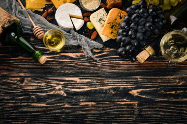 Ürün yelpazesine peynirler, brie peyniri, gorgonzola, mavi peynir, üzüm, bal, fındık, kırmızı ve beyaz şarap, ahşap bir masa üzerinde bir büyük. Üstten Görünüm. Metin için boş alan.