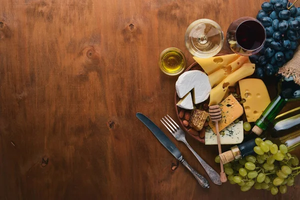 一瓶酒 一大堆奶酪 坚果和香料 在一个木桌上 顶部视图 文本的可用空间 — 图库照片