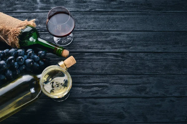 Una Botella Vino Con Copas Uvas Sobre Fondo Madera Negra —  Fotos de Stock