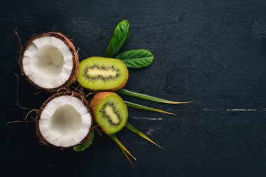 Hindistan cevizi ve kivi ahşap arka plan üzerinde. Tropikal meyve ve fındık. Üstten Görünüm. Metin için boş alan.