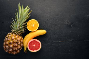 Taze tropikal meyve. Hindistan cevizi, ananas, kivi ve greyfurt. Ahşap bir arka plan üzerinde. Üstten Görünüm. Metin için boş alan.