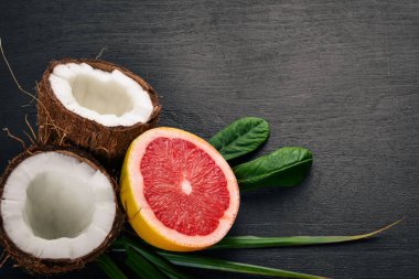 Hindistan cevizi ve greyfurt. Taze meyve. Ahşap bir arka plan üzerinde. Üstten Görünüm. Metin için boş alan.