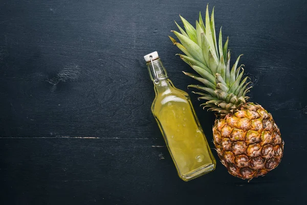 Fresh pineapple and pineapple juice. On a wooden background. Top view. Free space for text.