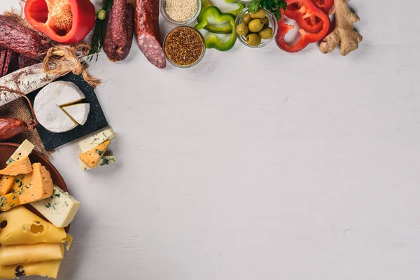 Peynir ve ahşap arka plan üzerinde geleneksel sosis ürün yelpazesine. Brie peyniri, mavi peynir, gorgonzola, fuete, salam. Metin için özgür yer. Üstten Görünüm.