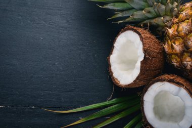 Hindistan cevizi ve ananas ahşap arka plan üzerinde. Tropikal meyve ve fındık. Üstten Görünüm. Metin için boş alan.